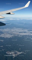 Aerial View of Cityscape with Airplane Wing Over Urban Landscape
