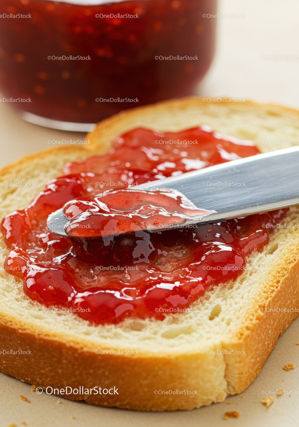 Spreading Sweet Strawberry Jam on Fresh White Bread