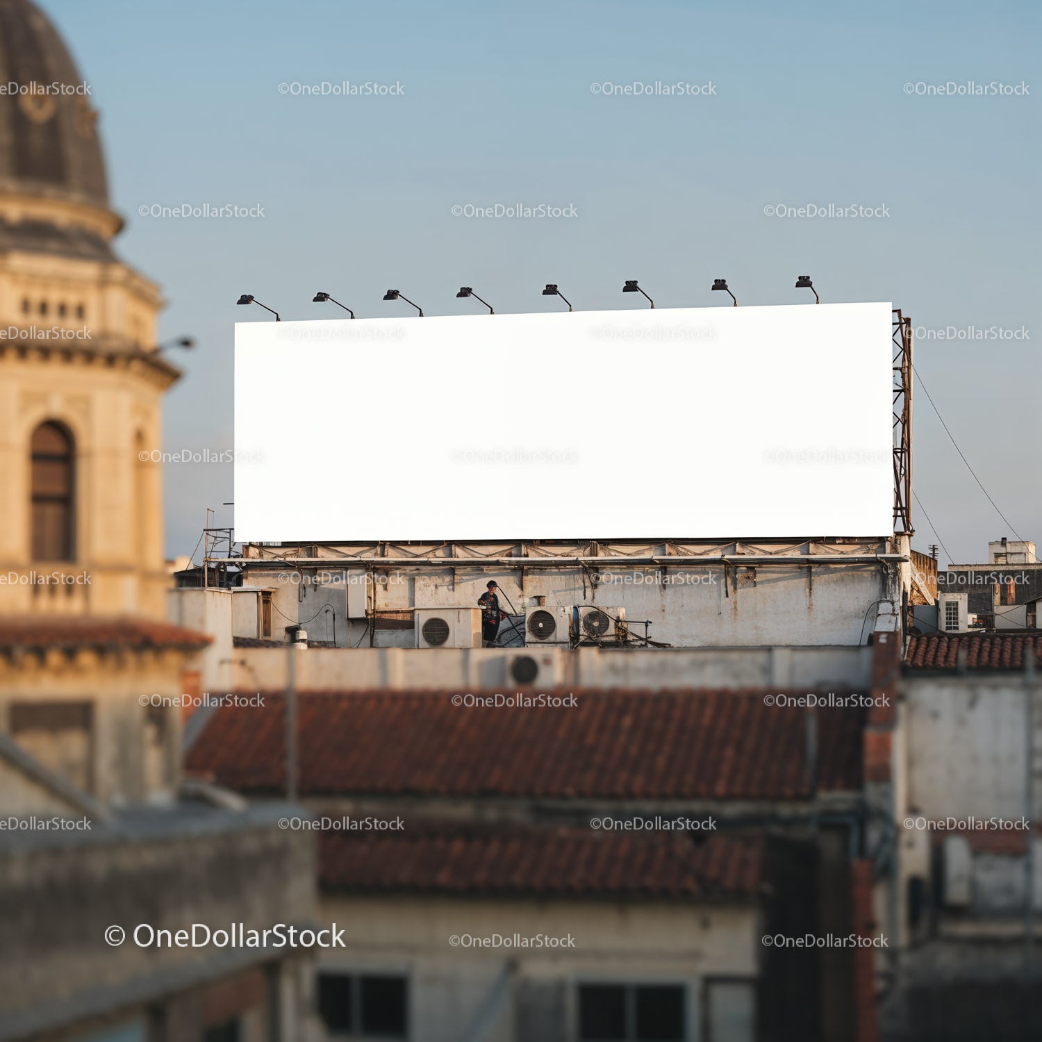 Pusty miejski billboard na dachu, na którym widać pracownika sprzątającego