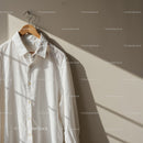 White Cotton Shirt Hanging on Wooden Hanger in Soft Light