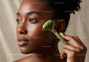 Elegant African Woman Using Jade Roller for Skincare Facial Massage