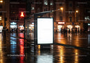 Empty Bus Stop Shelter at Night with Reflections in Wet Pavement