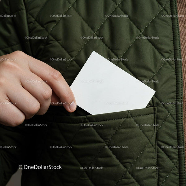 Person placing blank card into quilted jacket pocket JPG Mockup Image