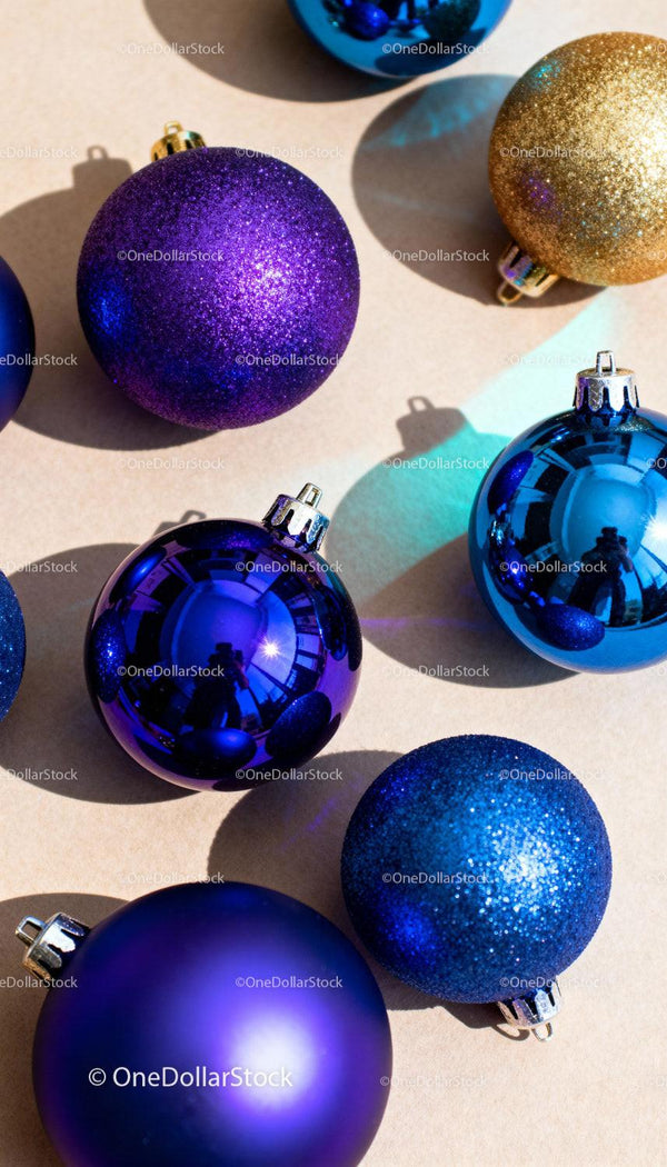 Colorful Blue and Gold Christmas Ornaments on Light Surface
