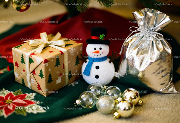 Festive Christmas gifts with snowman and ornaments under tree