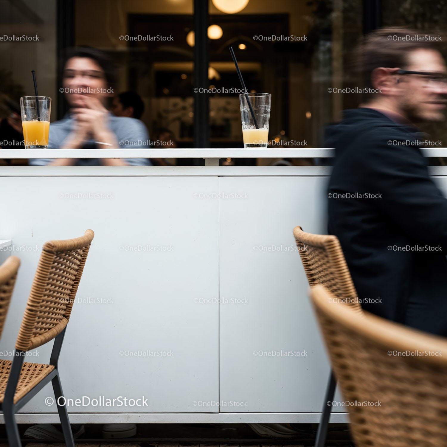 Blurred people and glasses on counter in modern cafe