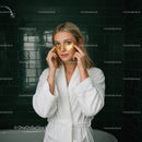 Young Woman Applying Gold Facial Masks in Spa Bathroom