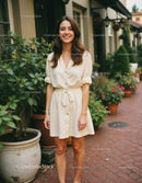 Young Woman in Beige Dress Enjoying Sunny Day in Urban Garden