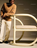 Young man leaning on modern beige chair in warm tones