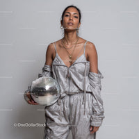 Stylish Woman in Metallic Outfit Holding Disco Ball for Modern Fashion