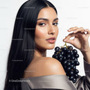 Elegant Woman with Long Black Hair Holding Black Grapes