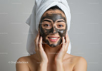 Woman with Black Mud Facial Mask Relaxing at Spa for Skin Rejuvenation
