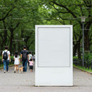 Blank white billboard in green park with walking family