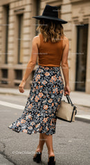 Stylish Woman in Floral Skirt and Black Hat Walking on City Street