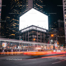 Busy urban street with glowing billboard at night