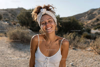 Smiling Woman with Curly Hair in White Tank Top on Desert Trail