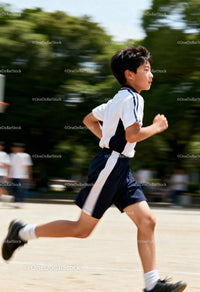 Active young boy running outdoors in sporty outfit