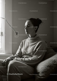 Contemplative Woman Sitting on Couch in Cozy Home Setting