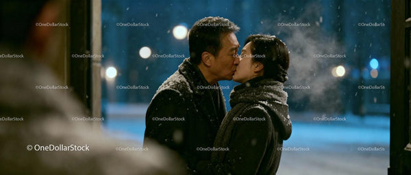 Couple Sharing a Tender Kiss on a Snowy Night