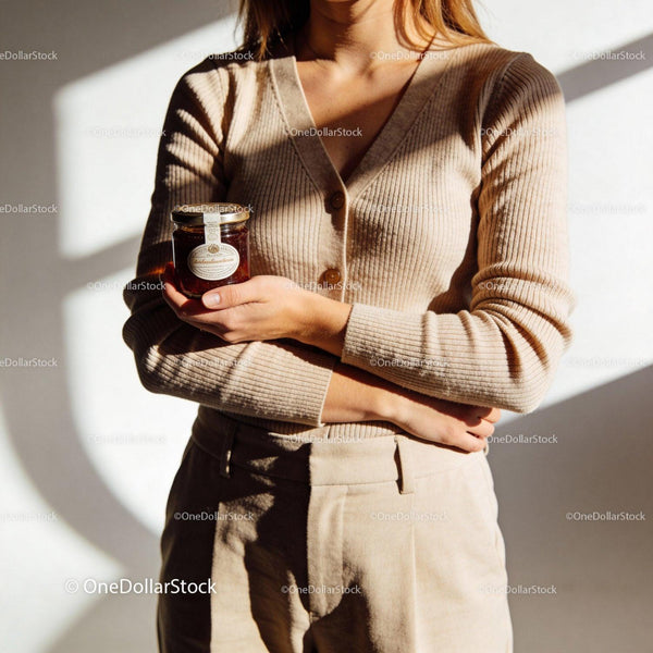 Woman holding small jar of homemade jam