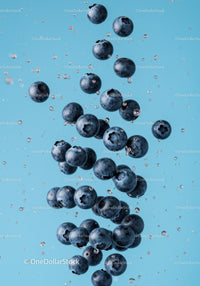 Fresh blueberries suspended in clear water splash