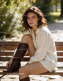Young woman sitting thoughtfully on park bench