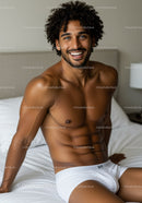 Smiling young man relaxing in white underwear on bed