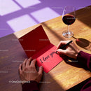 Person Writing I Love You Card by Wine Glass