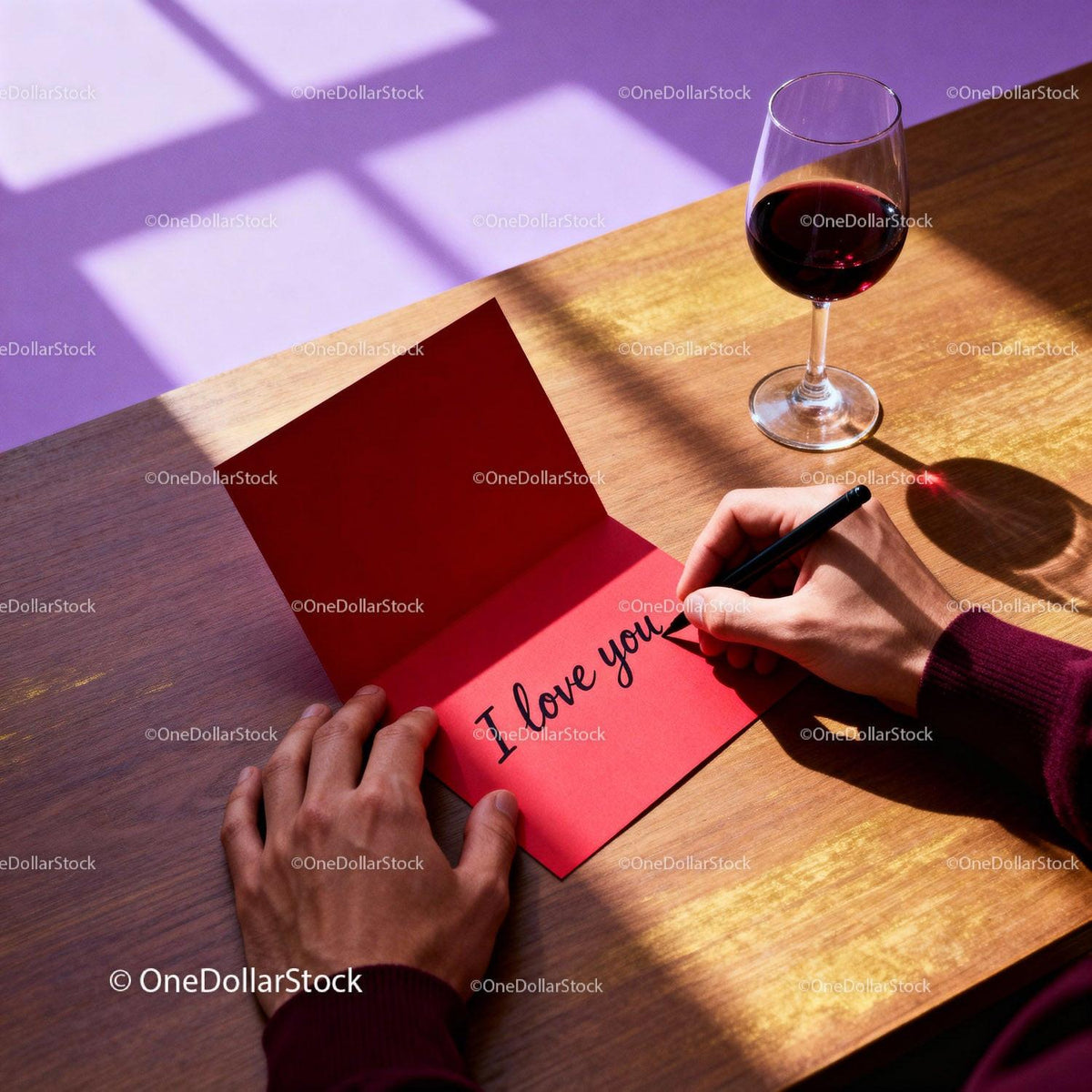 Person Writing I Love You Card by Wine Glass