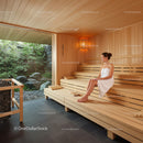 Relaxing Woman Sitting on Wooden Bench in Cozy Sauna Interior