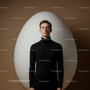 Calm young man standing in front of giant egg shape