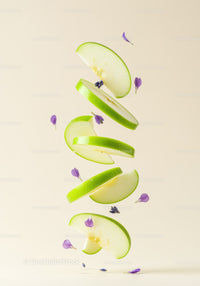 Floating green apple slices with delicate purple flowers