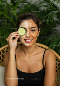Young Woman with Homemade Cucumber Facial Mask Relaxing in Spa