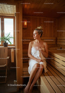 Relaxing Woman Sitting in Sauna with Wooden Interior and Natural Light