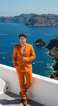 Man in Orange Suit Posing Near Blue Sea Cliff View