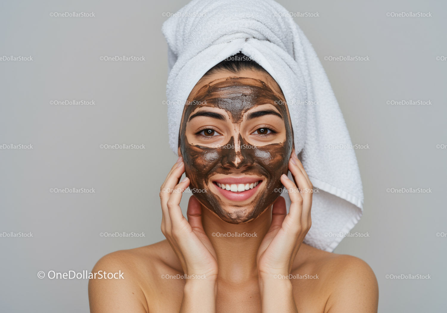 Young woman with brown facial mask and white towel wrap