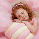 Little girl resting with giant pastel marshmallow toy
