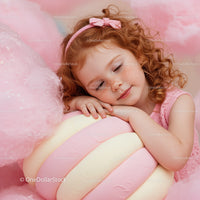 Little girl resting with giant pastel marshmallow toy