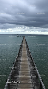 Wooden Pier Leading to Lighthouse Under Dramatic Cloudy Sky