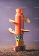 Orange smoothie bottle with apple slices on blocks