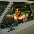 Young Man in Pink Shirt Driving Vintage Car on Summer Road Trip