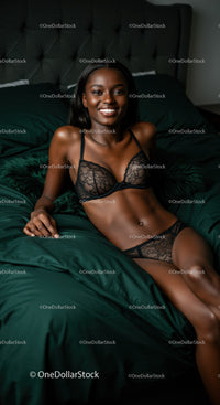 Smiling woman relaxing in black lace lingerie on bed