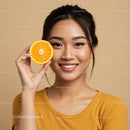 Beautiful Woman Holding Orange Slice Brightening Up Her Smile