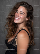 Portrait of a Smiling Woman with Curly Brown Hair and Black Lace Top