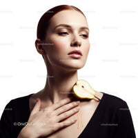 Elegant Woman with Green Pear and Black Clothing in Studio