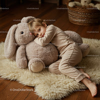 Child resting with oversized plush bunny on cozy rug