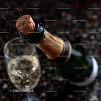 Champagne Bottle Cork Pop with Bubbles in a Glass for Celebration