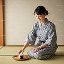 Woman in Yukata Serving Traditional Japanese Rice Ball
