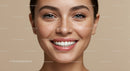 Close-up of young woman smiling with natural freckles