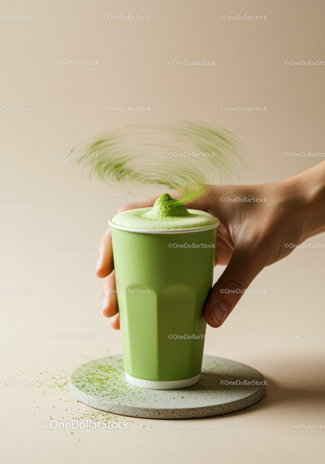 Hand Holding Green Matcha Latte with Powder Splash